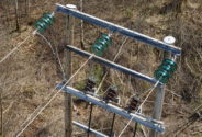 Detailed view of a section of a wooden transmission line pole with insulators